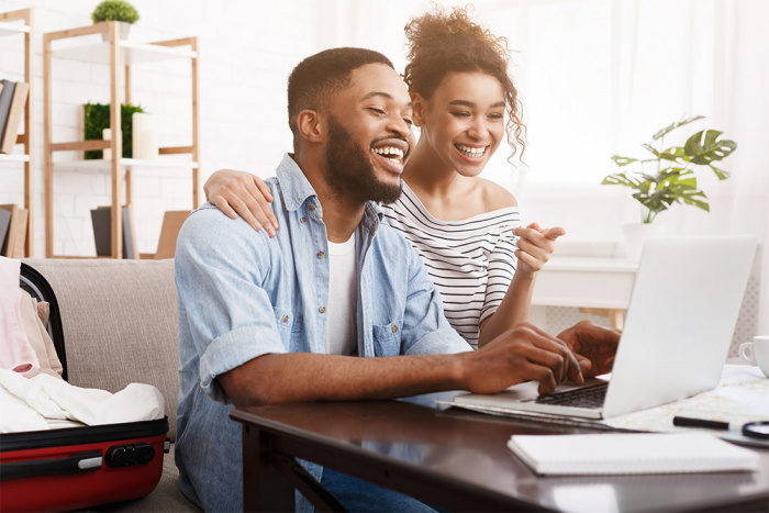 A couple smiling as they realize how easy it was to join a credit union from the comfort of their living room.