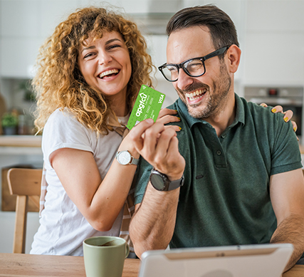 Smiling couple using their APGFCU Visa Cash Back Credit Card