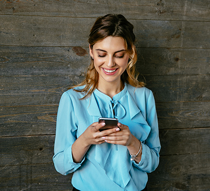 Young woman looking on her cellphone mobile checking her APGFCU checking account