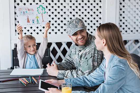 Military family sitting on porch after buying a home with an APGFCU VA loan.