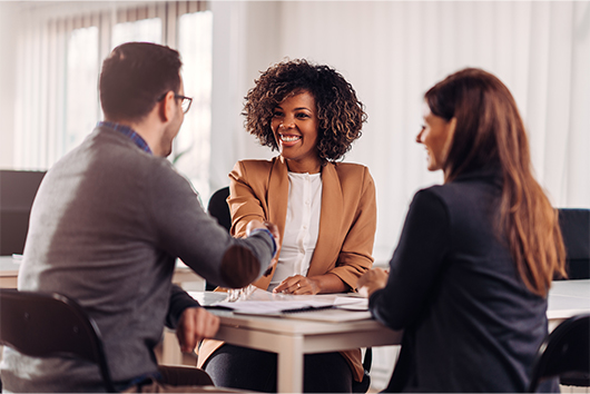 An APGFCU Business Representative shaking hands with a business couple about an APGFCU Business Loan