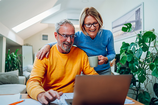 A couple in their 70s using their free debit card they got from  the MyTimes Plus program to shop online.