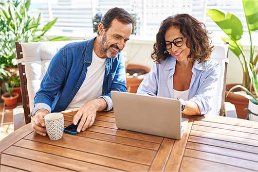 A 50-year-old couple smiling as they learn more about the APGFCU member services.