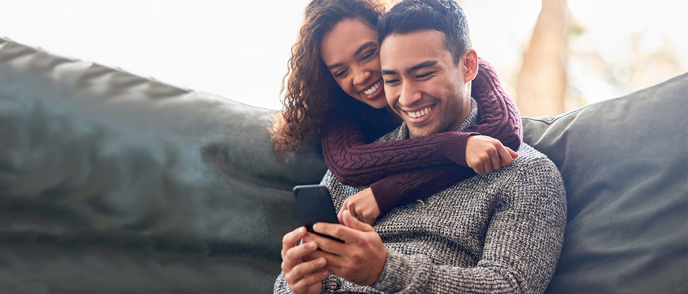 Smiling couple looking at phone at APGFCU High Yield Checking Account