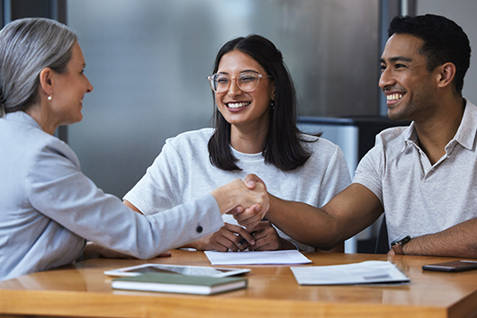 young couple sitting with an APGFCU financial representative