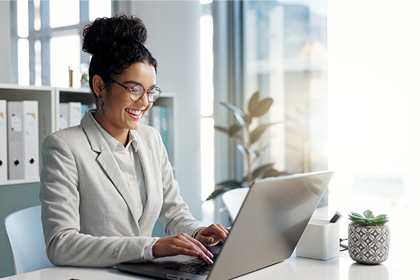 Smiling woman sitting at desk with laptop