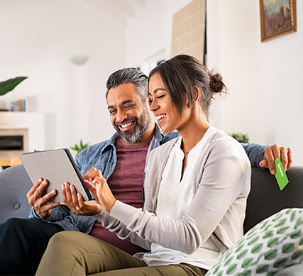 Smiling Couple using their APGFCU Visa Cash Back Credit Card